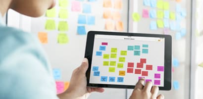 Young Lady using app to work on Kanban board setting up Kanban board
